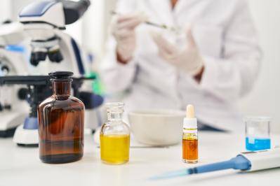 Young beautiful hispanic woman scientist holding plant with tweezers at laboratory